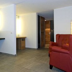 Ein eleganter Raum mit einem modernen Waschbecken und einer stilvollen roten Couch, die einladend wirkt.