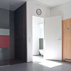 In einem stilvollen Spa-Bereich sind eine Holzsauna und ein Badezimmer sichtbar, ergänzt durch farbige Wandpaneele.