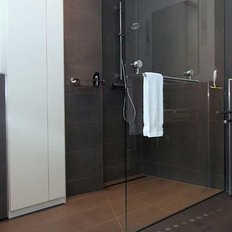 In diesem Badezimmer sind eine Dusche mit Glasabtrennung und ein modernes WC zu sehen, alles in einem zeitgemäßen Design.