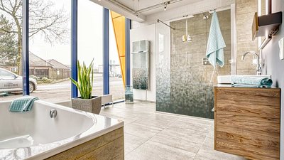 Das Badezimmer hat eine helle, einladende Atmosphäre mit grauen Fliesen und einem minimalistischen Design.