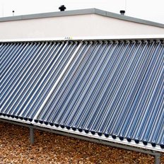 Auf einem Dach sind mehrere Solarrohre installiert, die in einem Winkel angeordnet sind, um Sonnenlicht zu sammeln und Energie zu erzeugen.