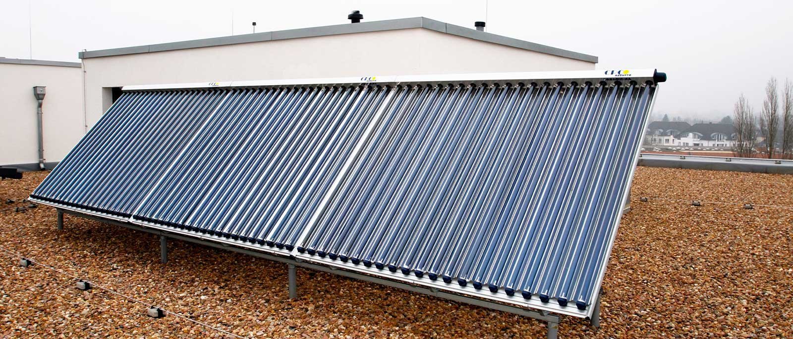 Auf einem Dach sind mehrere Solarrohre installiert, die in einem Winkel angeordnet sind, um Sonnenlicht zu sammeln und Energie zu erzeugen.