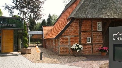 Die einladende Atmosphäre der Kromerei wird durch die blühenden Pflanzen und die gepflegte Landschaft unterstrichen.