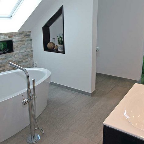 Ein elegantes Badezimmer-Design mit einer Badewanne, modernen Armaturen und einer dekorativen Wand mit Pflanzenmotiven.