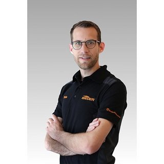 Der junge Mann lächelt leicht, während er in einem schwarzen Polohemd mit orangefarbenem Schriftzug posiert.